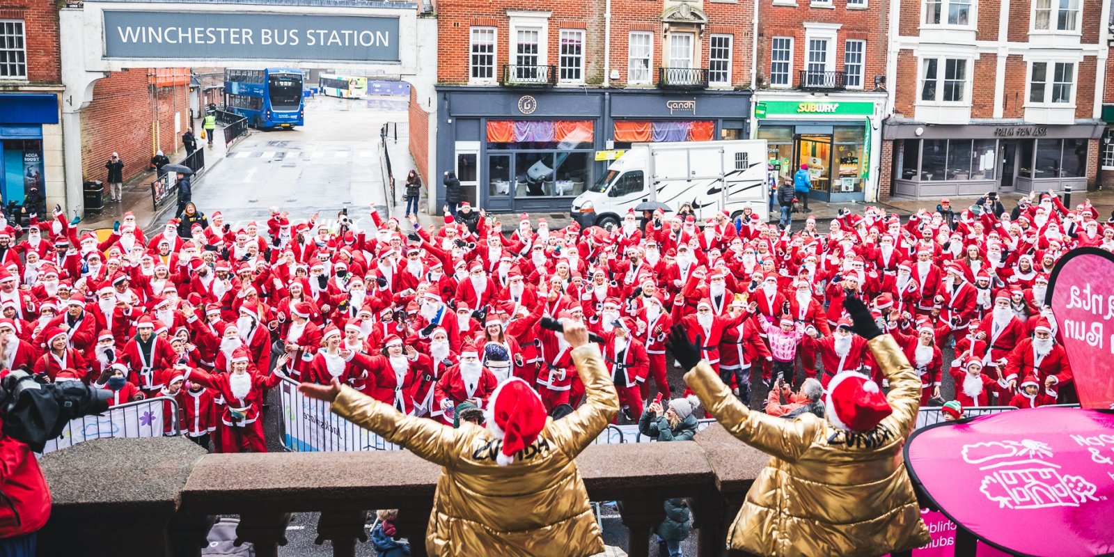 Hundreds_of_Santas_with_their_arms_up_in_front_of_Winchester_Bus_Station