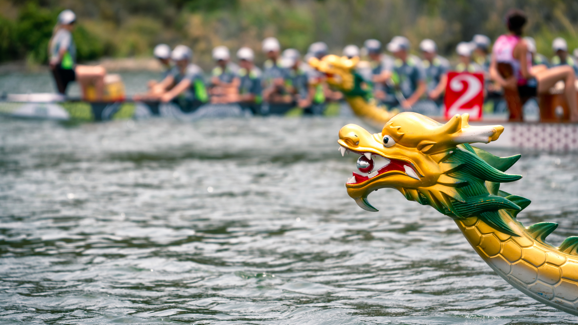 head of a dragon boat with boats racing in the distance