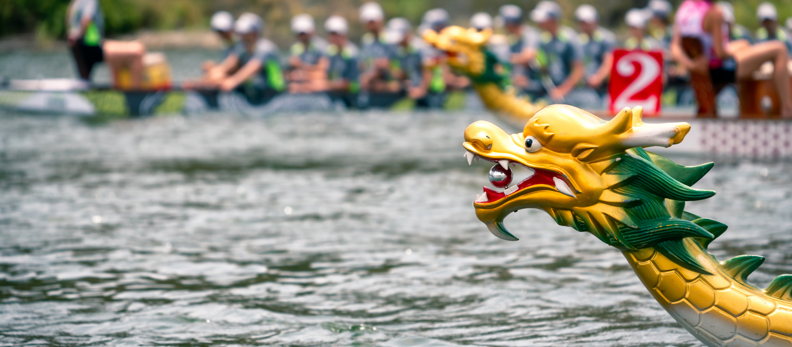 head of a dragon boat with boats racing in the distance