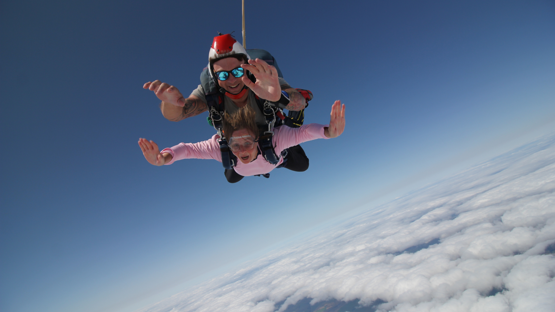 tandem skydive in the open sky with clouds below