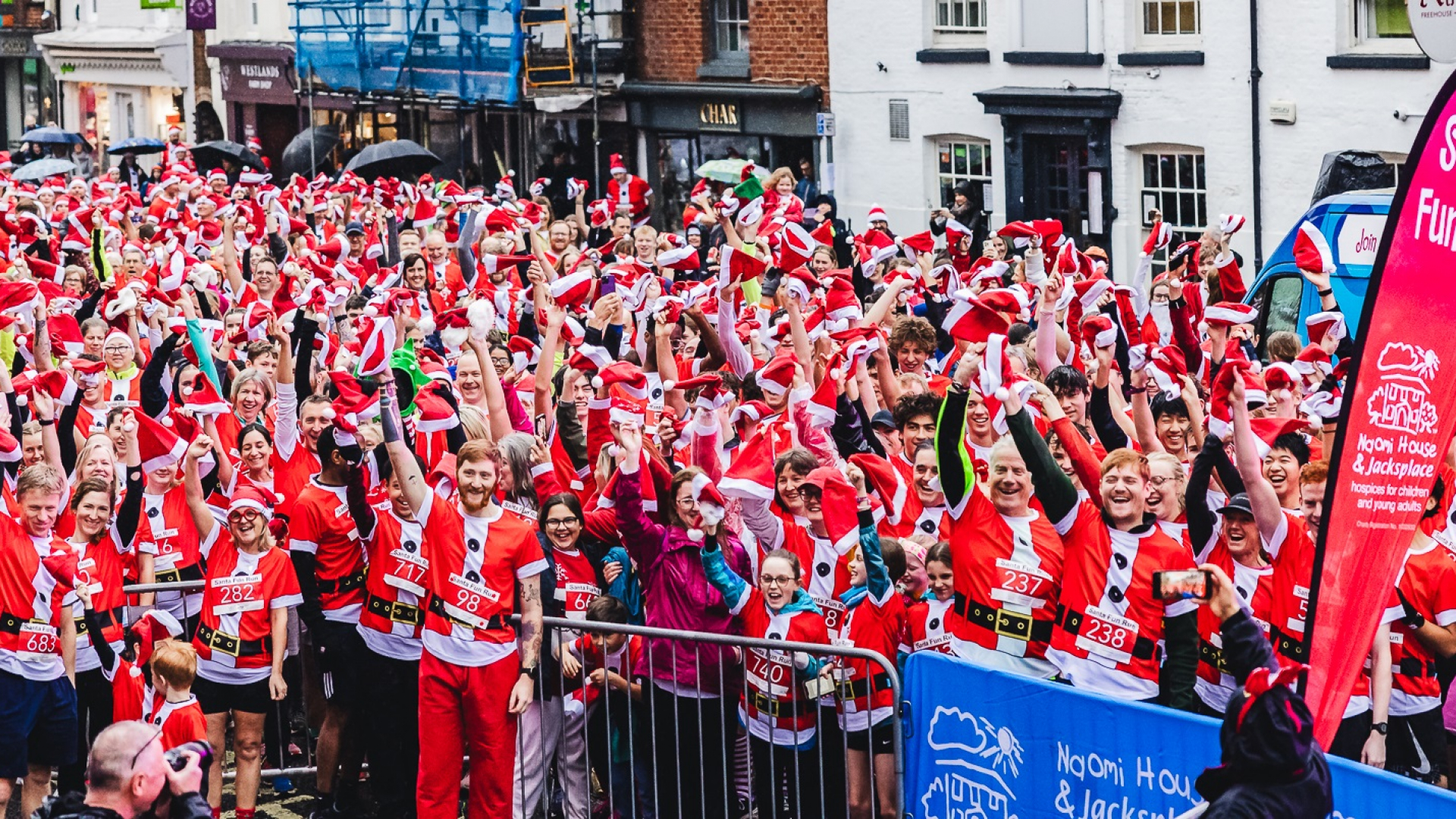 crowd of santas waving their santa hats